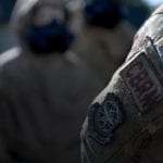 Airmen in protective suits and masks training for CBRN threats
