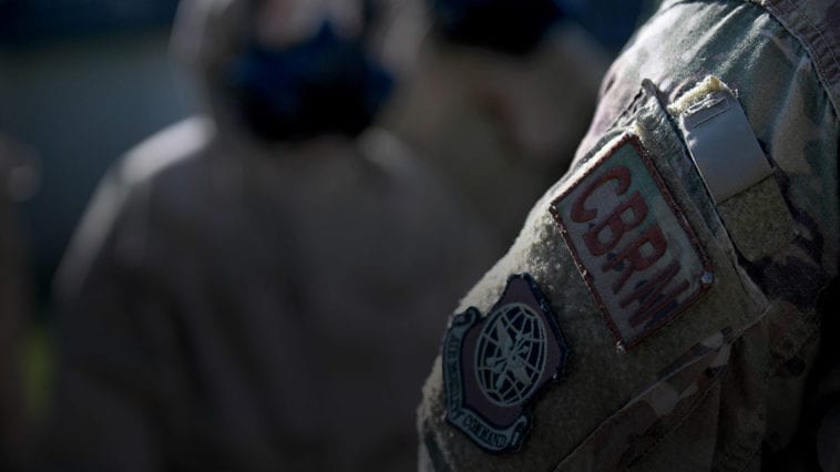 Airmen in protective suits and masks training for CBRN threats