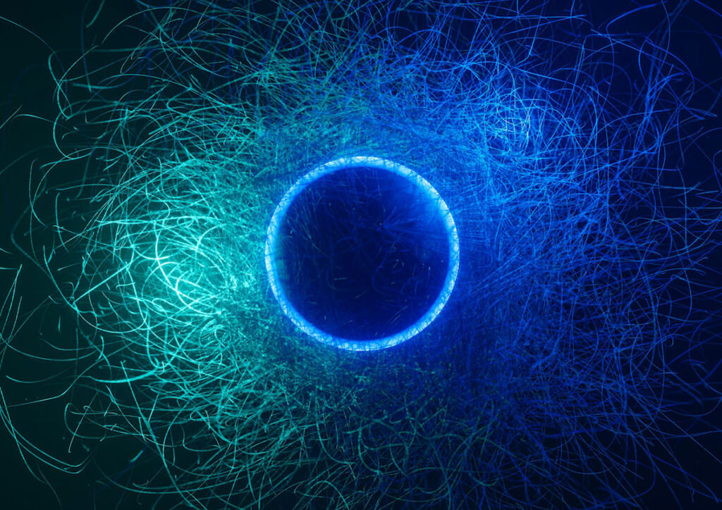 An abstract image showing a circular shape surrounded by chaotic, fine-line patterns symbolizing quantum entanglement and motion. Represents the conceptual principles behind quantum sensing technologies used for threat detection in defense and security contexts.